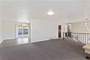 Empty room with a chandelier and carpet floors