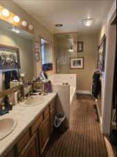 Bathroom with tiled bath and double sink vanity