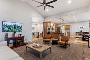 Living room featuring high vaulted ceiling, sink, ceiling fan, and hardwood / wood-style flooring
