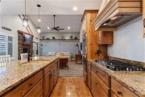 Kitchen with appliances with stainless steel finishes, ceiling fan, light carpet, sink, and hanging light fixtures