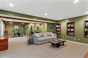 Living room with light colored carpet and built in shelving