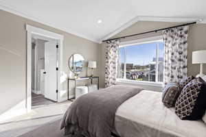 Bedroom with lofted ceiling, light hardwood / wood-style floors, and ornamental molding