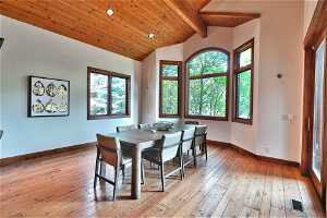 Dining space featuring wood ceiling, light hardwood / wood-style floors, and vaulted ceiling with beams