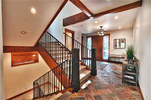 Foyer featuring beam ceiling and dark tile floors
