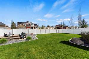 Large backyard with a patio area and an outdoor fire pit,