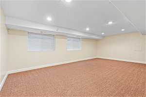Large Basement  entertaining room with light carpet