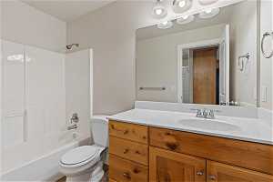 Full bathroom featuring vanity with extensive cabinet space, toilet, and bathing tub / shower combination