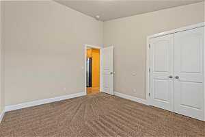 Upstairs bedroom with light colored carpet, high vaulted ceiling