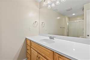 Bathroom with a shower with door and large vanity