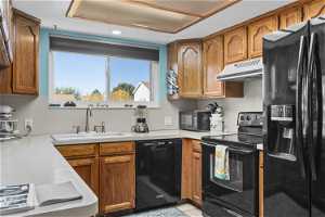 Kitchen with black appliances and sink