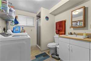 Laundry area with washing machine and clothes dryer, light tile floors, and sink