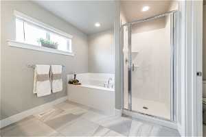 Bathroom with shower with separate bathtub, toilet, and tile flooring
