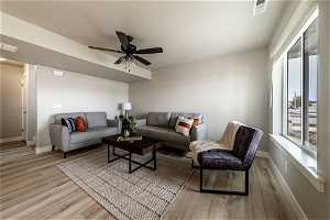 Living room with ceiling fan and light hardwood / wood-style floors