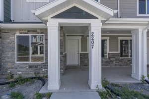 Entrance to property featuring covered porch