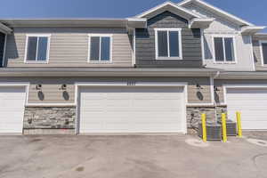 View of property featuring a garage and central AC