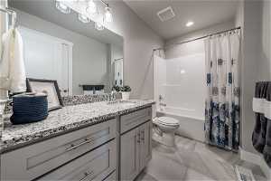 Full bathroom with oversized vanity, shower / bath combo, toilet, and tile flooring