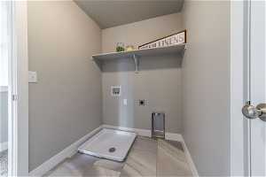 Washroom with hookup for an electric dryer, light tile floors, and hookup for a washing machine