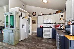Kitchen featuring dark wood-type flooring, white cabinets, sink, and white appliances