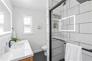Remodeled Bathroom with a large shower enclosure and oversized vanity with lighted mirror