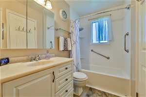 Full bathroom with shower / bath combo, toilet, oversized vanity