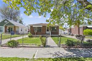 Bungalow-style home with a front lawn, fully fenced