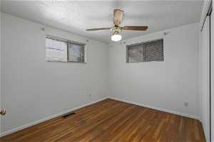 Spare room featuring dark hardwood / wood-style flooring and ceiling fan