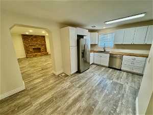Kitchen featuring a sink, light hardwood / wood-style floors, stainless steel appliances, and butcher block counters