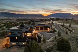 View of front of property featuring a mountain view, driveway, a patio area, and stone siding