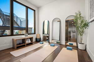 Workout room with a barn door, dark wood-type flooring, and plenty of natural light
