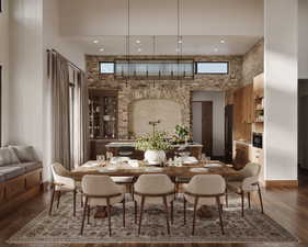 Dining space featuring a towering ceiling and hardwood / wood-style flooring