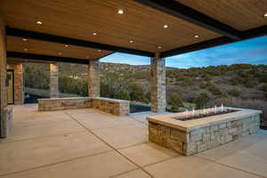 View of patio with an outdoor fire pit and a mountain view