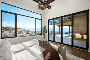Bedroom featuring a mountain view, hardwood / wood-style floors, access to outside, and multiple windows