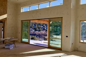 Doorway featuring a towering ceiling and a healthy amount of sunlight