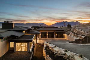 View of front of home with driveway, a mountain view, a patio area, and a garage