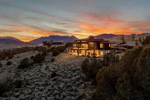 Back of house featuring a mountain view, a chimney, and a patio