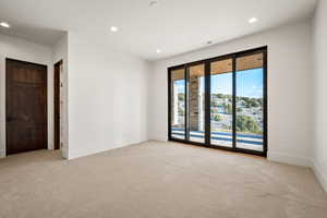 Unfurnished room with light colored carpet and recessed lighting