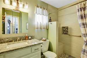 Bathroom with walk in shower, large vanity, and toilet