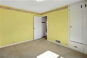 Unfurnished bedroom with light carpet