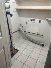 Laundry room featuring gas dryer hookup, hookup for an electric dryer, light tile flooring, and washer hookup