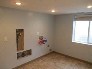 Laundry room with a wealth of natural light, hookup for a washing machine, electric dryer hookup, and tile flooring