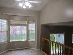 Unfurnished room featuring ceiling fan and vaulted ceiling