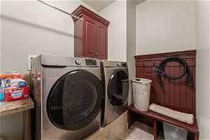 Laundry area featuring washer and dryer and cabinets