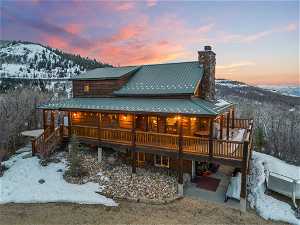 Snow covered property featuring a deck with mountain view