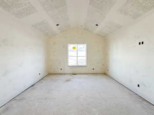 Empty room with vaulted ceiling