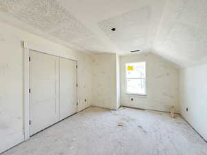 Bonus room with a textured ceiling and lofted ceiling