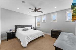 Master Bedroom with light colored carpet, ceiling fan, and multiple windows