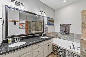 Bathroom with dual sinks, oversized vanity, and plus walk in shower