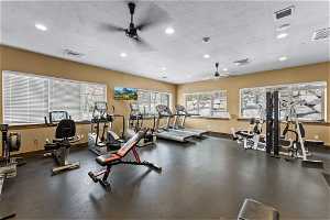 Workout area with a textured ceiling and ceiling fan