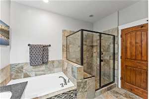 Bathroom with tile flooring, vanity, a textured ceiling, and separate shower and tub
