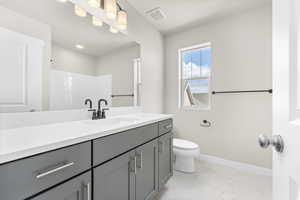 Bathroom featuring tile floors, vanity, and toilet